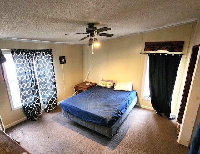 carpeted bedroom featuring a textured ceiling, ornamental molding, and a ceiling fan