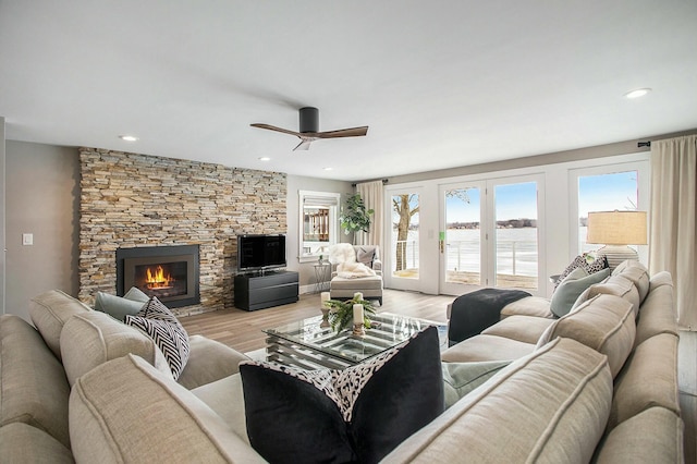 living area featuring recessed lighting, a fireplace, a ceiling fan, and light wood-style floors