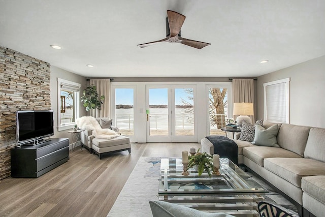 living area with ceiling fan, wood finished floors, a wealth of natural light, and recessed lighting