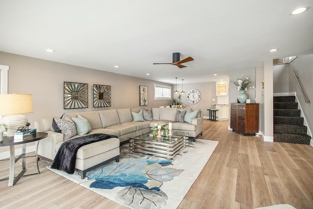 living room featuring stairs, light wood-type flooring, baseboards, and recessed lighting