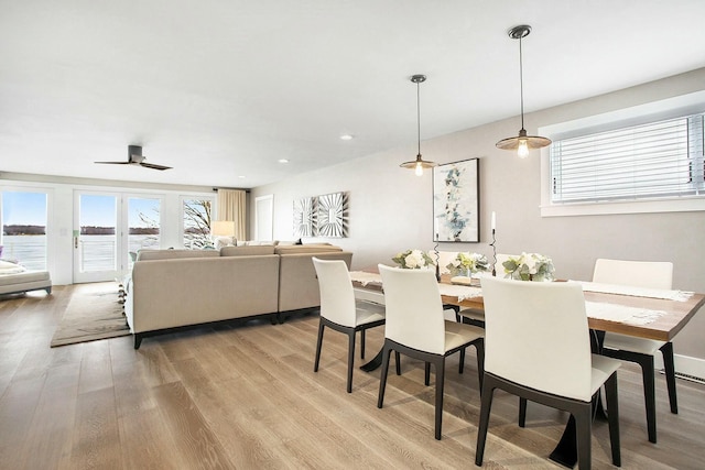 dining area with light wood-style floors, a ceiling fan, and a wealth of natural light