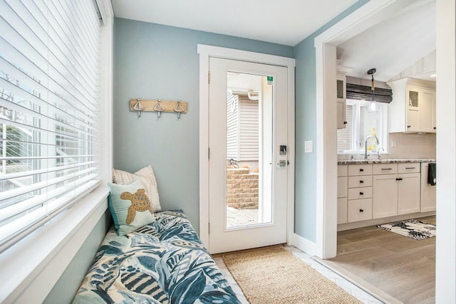 entryway featuring light wood finished floors and a sink