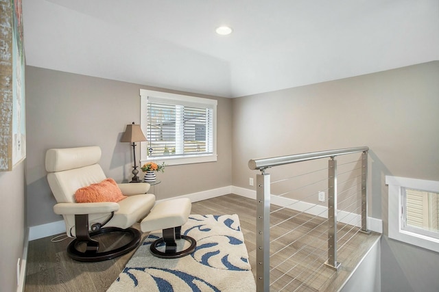 sitting room with vaulted ceiling, wood finished floors, an upstairs landing, and baseboards