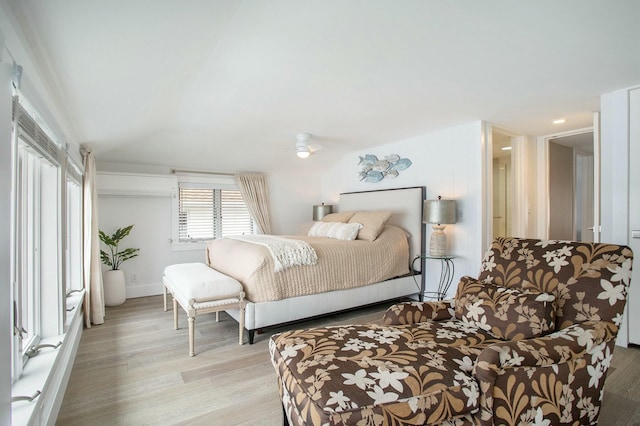 bedroom featuring vaulted ceiling, light wood finished floors, and baseboards