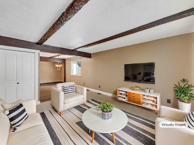 living room featuring carpet, beam ceiling, baseboards, and a textured ceiling