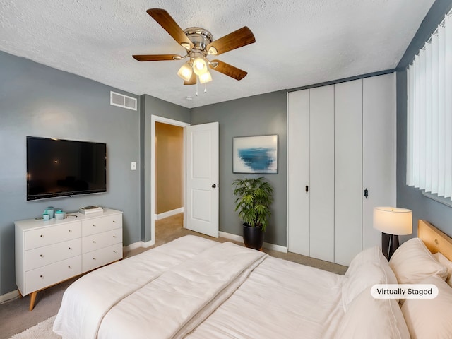 bedroom featuring a closet, visible vents, ceiling fan, a textured ceiling, and baseboards