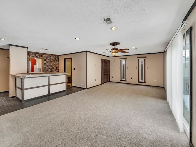 unfurnished living room featuring a wealth of natural light, carpet, and ornamental molding