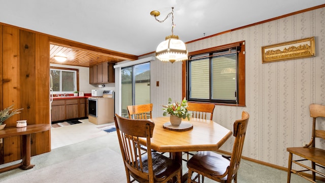 dining area featuring light colored carpet, baseboards, and wallpapered walls