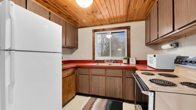 kitchen featuring white appliances, a sink, wood ceiling, light floors, and brown cabinetry