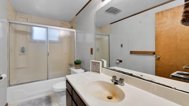 bathroom with visible vents, toilet, combined bath / shower with glass door, vanity, and tile walls