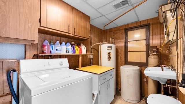 washroom with washer / clothes dryer, visible vents, wood walls, a sink, and laundry area