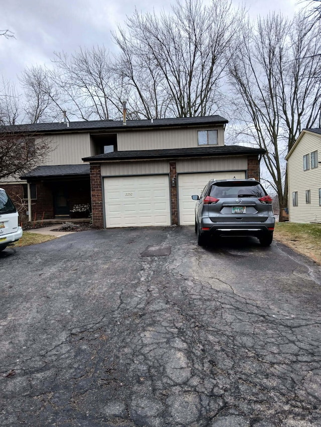 exterior space with a garage, driveway, and brick siding