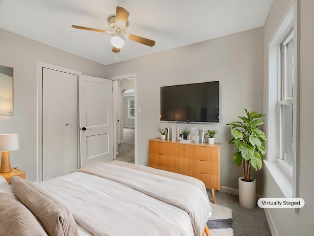 bedroom featuring carpet floors, baseboards, arched walkways, and a ceiling fan