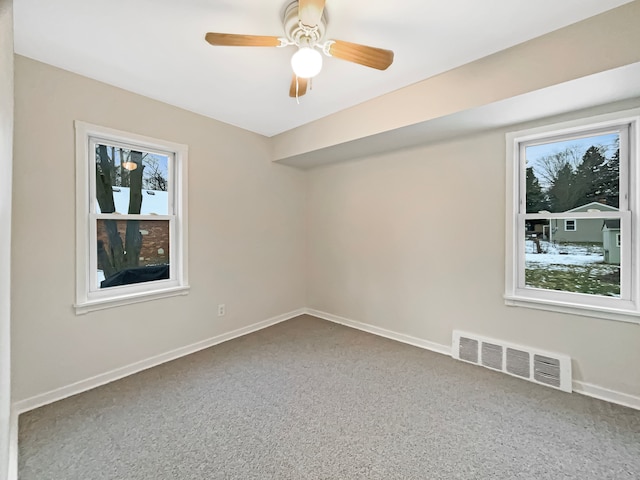 carpeted spare room with visible vents, plenty of natural light, and baseboards