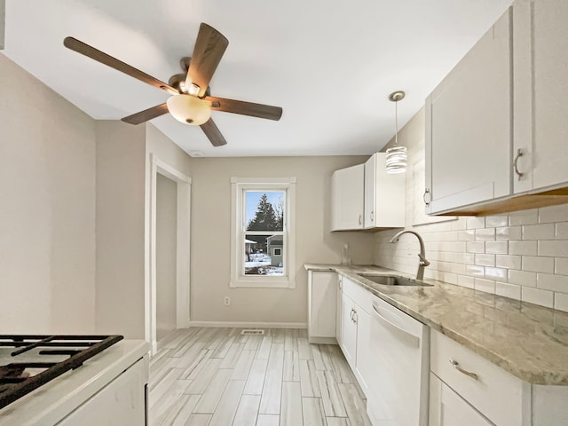 kitchen featuring light stone counters, tasteful backsplash, white cabinetry, white dishwasher, and a sink