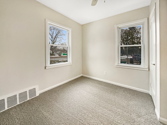 unfurnished room with baseboards, visible vents, and ceiling fan