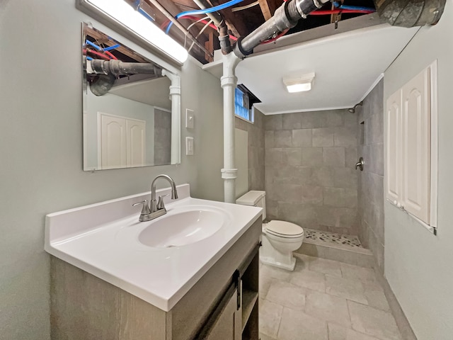 bathroom featuring tiled shower, vanity, and toilet