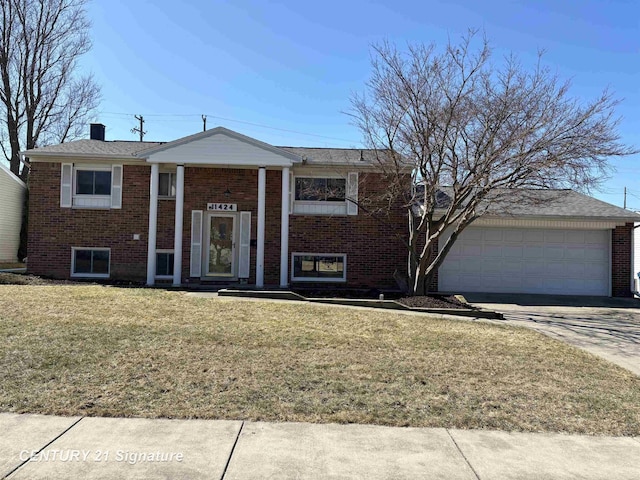 bi-level home featuring a garage, brick siding, concrete driveway, and a front lawn