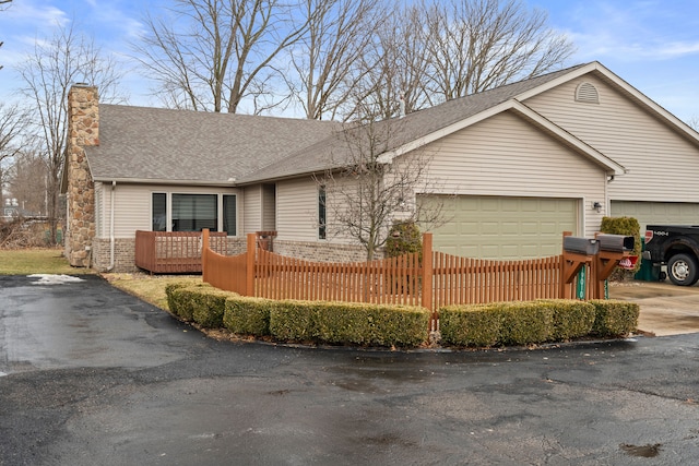 ranch-style home featuring a garage, a shingled roof, fence, driveway, and a chimney