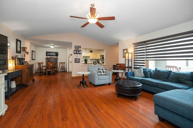 living area with vaulted ceiling, ceiling fan, and wood finished floors