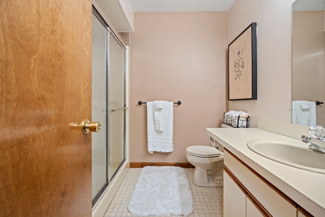 bathroom with toilet, a stall shower, a textured ceiling, vanity, and baseboards