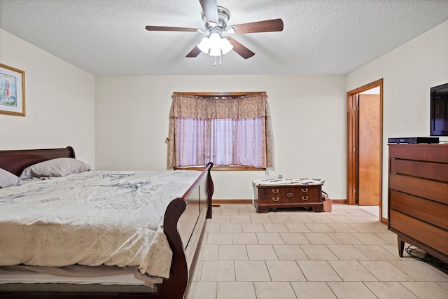 bedroom with ceiling fan, baseboards, and a textured ceiling