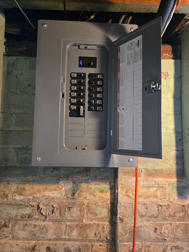 utility room with electric panel and a garage