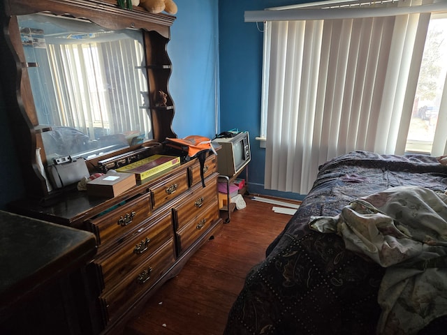 bedroom featuring multiple windows and dark wood-style floors