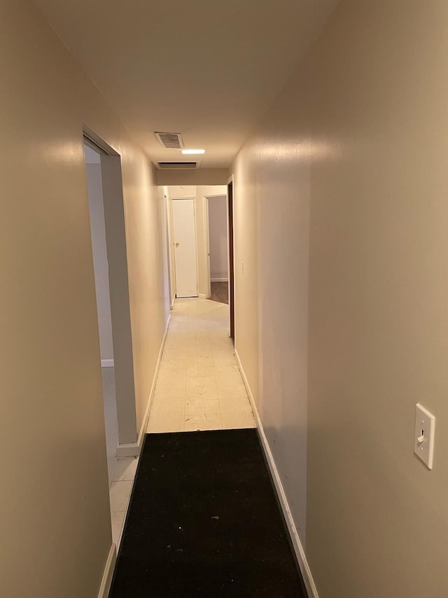 hall with baseboards and visible vents