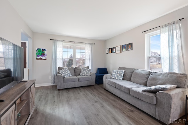 living area with light wood-type flooring and baseboards