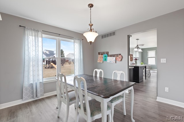 dining space with visible vents, baseboards, and wood finished floors