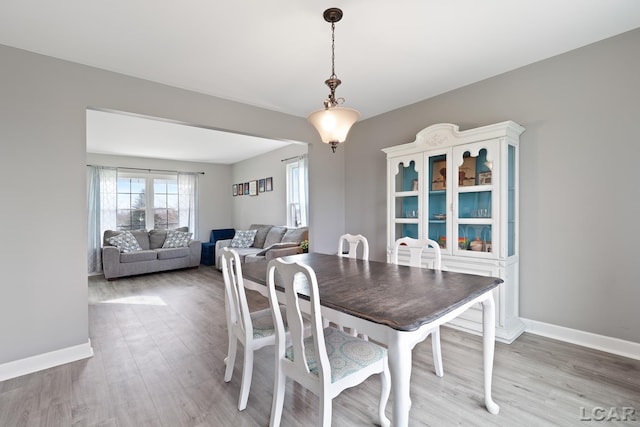 dining space featuring wood finished floors and baseboards