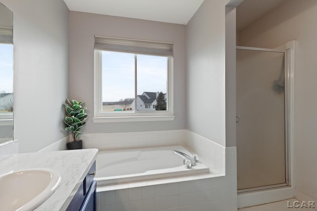 bathroom featuring a bath, a stall shower, and vanity