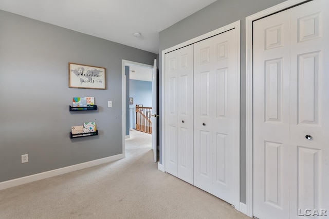 bedroom with light carpet and baseboards