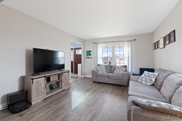 living area with light wood-style flooring and baseboards