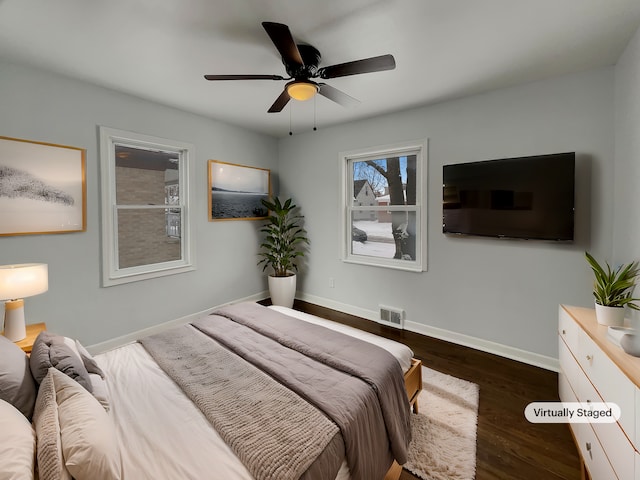 bedroom with dark wood-type flooring, visible vents, baseboards, and a ceiling fan