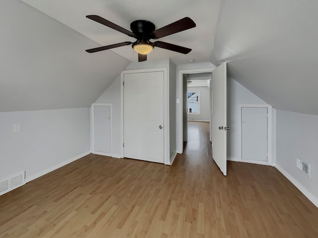 additional living space featuring vaulted ceiling, wood finished floors, visible vents, and baseboards