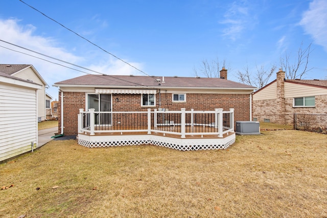 back of property featuring a yard, fence, and brick siding