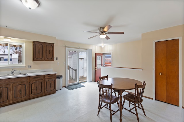 dining area with light floors, a ceiling fan, and baseboards