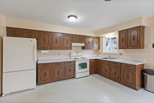 kitchen featuring under cabinet range hood, white appliances, a sink, light countertops, and light floors