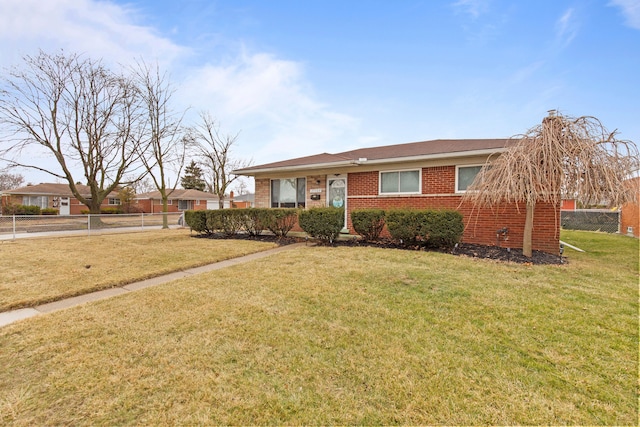 view of front of home featuring brick siding, fence, and a front lawn