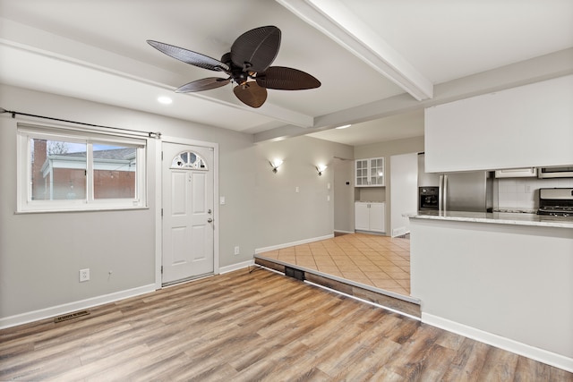 entryway featuring baseboards, visible vents, ceiling fan, beamed ceiling, and light wood-style floors