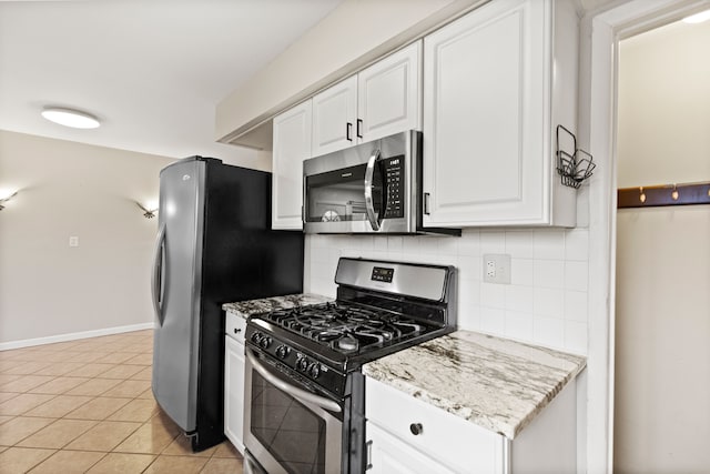 kitchen with light tile patterned floors, white cabinetry, appliances with stainless steel finishes, and decorative backsplash