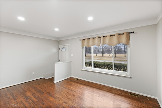 spare room featuring recessed lighting, wood finished floors, visible vents, and baseboards