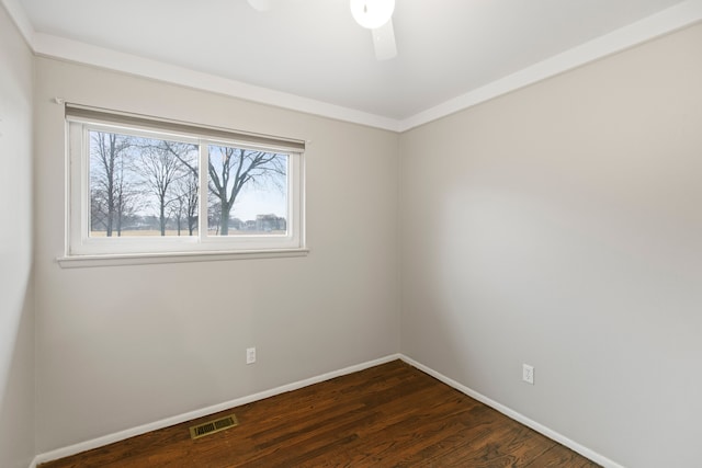 empty room with dark wood-style floors, ceiling fan, visible vents, and baseboards