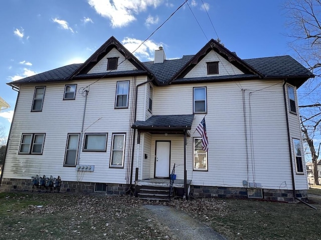 victorian-style house featuring a chimney and roof with shingles