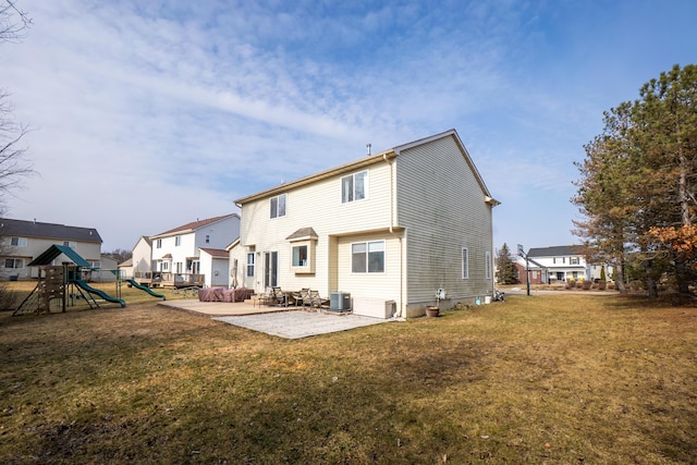 back of property featuring a playground, a yard, a patio area, central AC, and a residential view