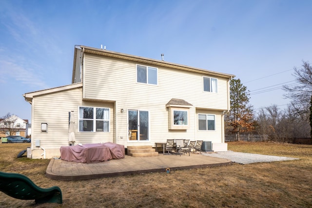 rear view of property with entry steps, a lawn, central AC, and a patio