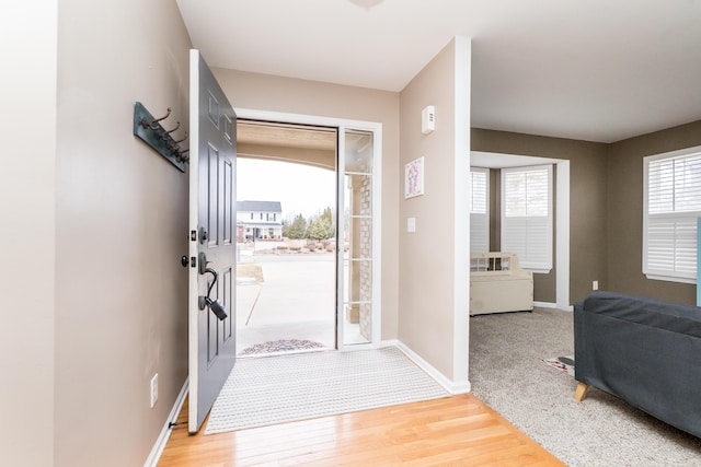 foyer entrance with light wood-style flooring and baseboards