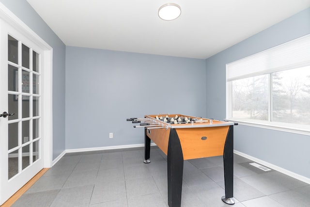 rec room with visible vents, baseboards, and tile patterned floors